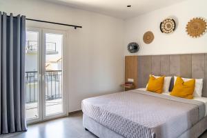 a bedroom with a large bed with yellow pillows at Cactus in Skiathos