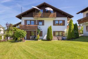 a house with a green lawn in front of it at Ferienwohnung Krokus in Weiler-Simmerberg
