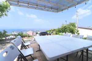 a table and chairs on a patio with a view of the ocean at Private House ROUTE61 in Oama