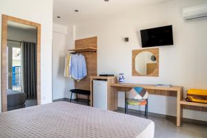 a bedroom with a bed and a desk with a mirror at Cactus in Skiathos