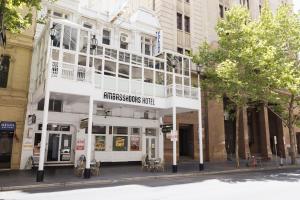 a white building on the corner of a street at Ambassadors Hotel in Adelaide