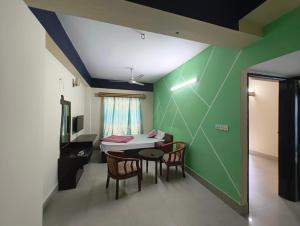 a dining room with a table and chairs and a room with green walls at Hotel World Beach Resort in Cox's Bazar