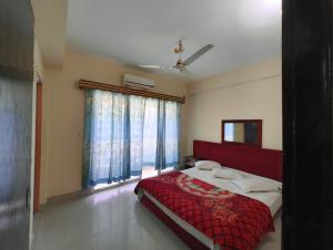 a bedroom with a red bed and a large window at Hotel World Beach Resort in Cox's Bazar