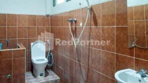 a bathroom with a shower and a toilet and a sink at The SO Hotel Mitra RedDoorz in Pangandaran