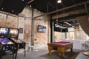 a room with a ping pong table and a video game at Ambassadors Hotel in Adelaide