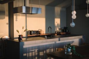 a kitchen with a counter with a sink and a microwave at TORIKKA Stay -ビーチに建つ貸別荘- in Sumoto