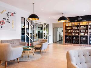 a room with couches and chairs and a table at Mercure Tours Sud in Joué-lès-Tours