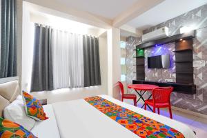 a hotel room with a bed and a table with chairs at FabHotel Skyview in Bhopal
