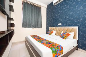 a bedroom with a bed and a blue wall at FabHotel Skyview in Bhopal +25 photos