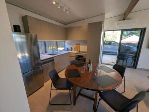 a kitchen with a wooden table and chairs in a kitchen at The Mandurah Hideaway in Mandurah +11 photos