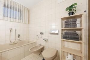 a bathroom with a toilet and a tub and a sink at Apartment am Bischofsberg in Großheubach +22 photos