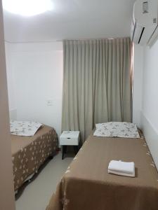 A bed or beds in a room at Rosa Branca Facilities Apartamentos