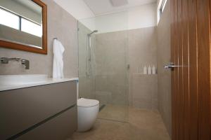a bathroom with a shower and a toilet and a sink at The Mandurah Hideaway in Mandurah