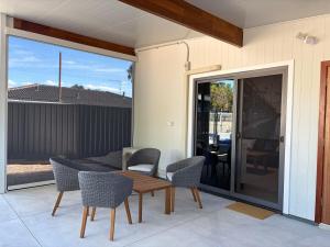 a patio with a table and chairs and a sliding glass door at The Mandurah Hideaway in Mandurah