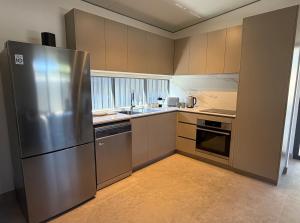 a large kitchen with a stainless steel refrigerator at The Mandurah Hideaway in Mandurah
