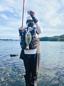 a person holding a fish on a pole in the water at 아라무사aramoosa민숙 in Tsushima