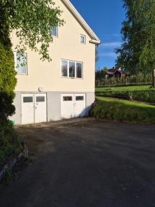 a house with two garage doors and a driveway at Lägenhet i Sandhem in Sandhem