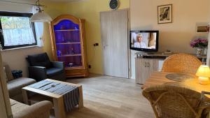 a living room with a tv and a table at Ferienwohnungen Stollhof in Mehring