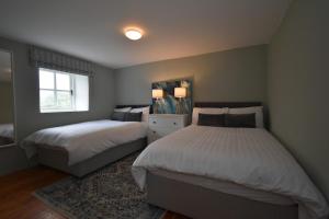 a bedroom with two beds and a window at High Field Cottage Rosscarbery in Rosscarbery