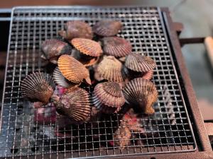 a group of clams on a grill on a table at 아라무사aramoosa민숙 in Tsushima