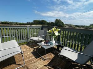 a patio with two chairs and a table on a deck at High Field Cottage Rosscarbery in Rosscarbery