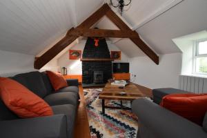 a living room with a couch and a fireplace at High Field Cottage Rosscarbery in Rosscarbery