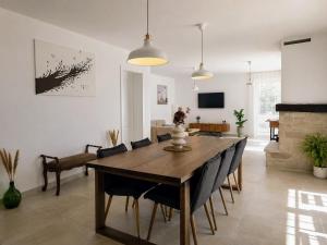 a living room with a dining room table and a couch at Villa Gaudeo with pool and EV station in Nova Vas