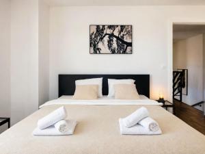 a bedroom with a large bed with two white pillows at Villa Gaudeo with pool and EV station in Nova Vas +30 photos