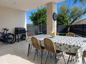 a table with chairs and a clock on a patio at Villa Gaudeo with pool and EV station in Nova Vas