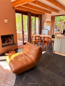 a living room with a leather couch and a table at Five Trees Forest Home in Lanaken