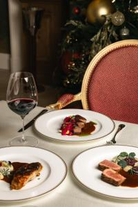 a table with three plates of food and a glass of wine at Winery La Gora in Irig