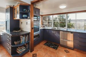 a kitchen with blue cabinets and a counter top at Timata Ora - 7BR family home in prime location in New Plymouth +12 photos