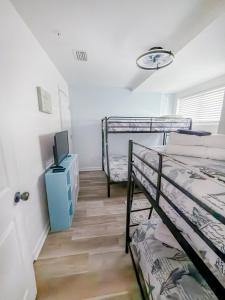 a room with two bunk beds and a tv at Beach Paradise - Perfect Ocean Sunset Views with Pool & Sauna & Breakfast! in Mexico Beach +89 photos