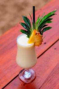 a drink with a pineapple on a wooden table at Diana Residence in Matara