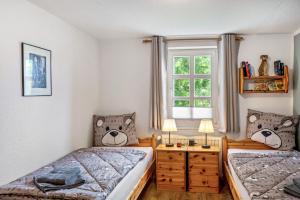 a bedroom with two twin beds and a window at Dommelhof Ferienwohnungen in Diemelsee