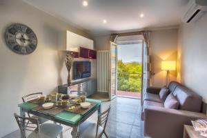 a living room with a table and a couch and a clock at Versilia Residence in Lido di Camaiore