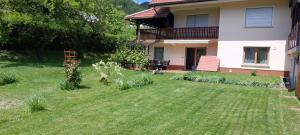 a house with a yard in front of it at Apart House ROJER in Ljubno