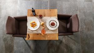 a table with two plates of food on top of a couch at Nebbiolo Wine B&B - Winery & Vineyard Valtellina in Castione Andevenno