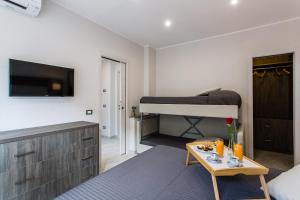 uma sala de estar com uma cama e uma mesa num quarto em Versilia Residence em Lido di Camaiore