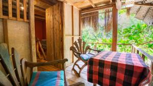 a room with a table and chairs on a porch at Sigiriya River Side Villa in Sigiriya