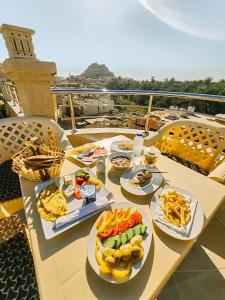 a table with plates of food on a balcony at Nigmt Siwa Hotel in Siwa