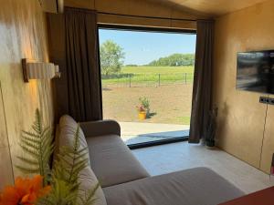 a living room with a couch and a large window at ChillHouse 2 in Békésszentandrás