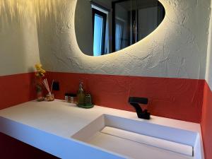a bathroom sink with a round mirror above it at ChillHouse 2 in Békésszentandrás +12 photos