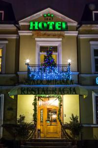 ein Weihnachtsbaum an der Vorderseite eines Hotels in der Unterkunft Hotel Staromiejski in Krasnystaw