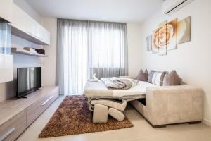 a bedroom with a bed and a flat screen tv at Fior Apartments in Merano