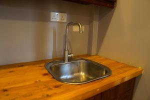 a kitchen sink with a faucet on a wooden counter at Diana Residence in Matara +22 photos