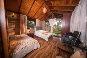 a bedroom with two beds and a television in it at Las Cabañas La Libertad in Macanal