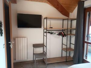 a room with a tv on the wall and a chair at Castle house in Aprica