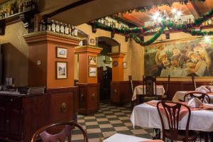 a restaurant with two tables and a painting on the wall at Hotel Staromiejski in Krasnystaw