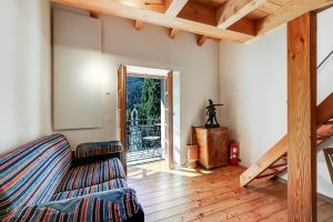 a living room with a couch and an open door at Mille Colline la Casa 1 with Shared Pool - Happy Rentals in Pianezzo